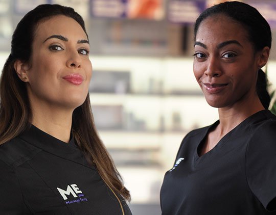Two massage therapists smiling