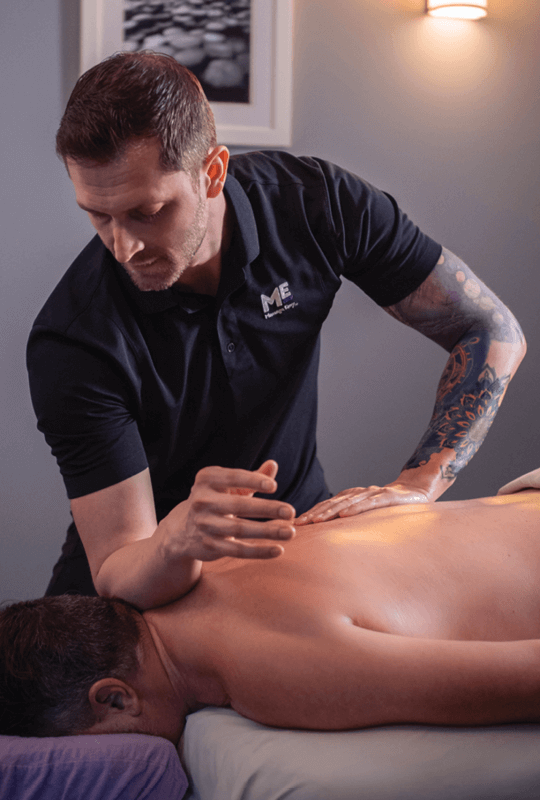 Man lying face down on table as he receives a massage. 