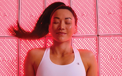 Woman relaxing with her eyes closed during Full Body LED Light Therapy session. 