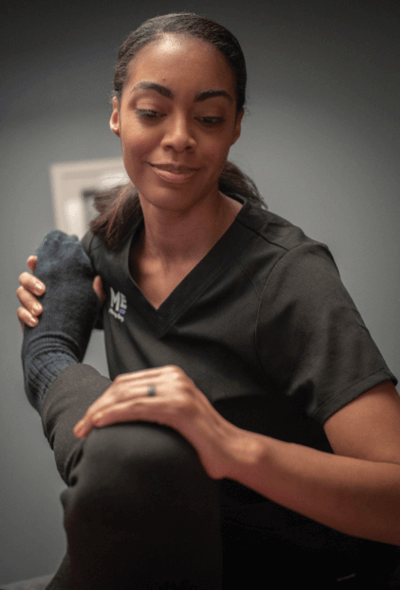 Close-up of therapist as she stretches a client's leg. 