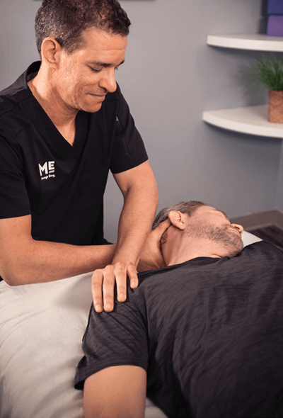 Man turning to the side as his neck is stretched by therapist. 