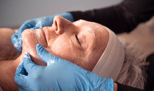 Close-up of esthetician's hands as she performs Age-Defying Chemical Peel service. 