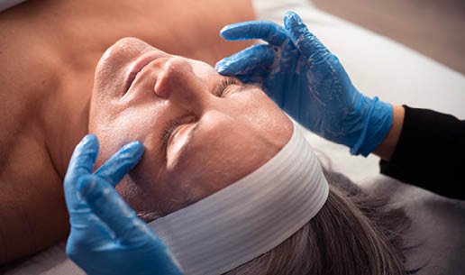 Close-up of esthetician's hands as she performs Tone-Balancing Chemical Peel service. 