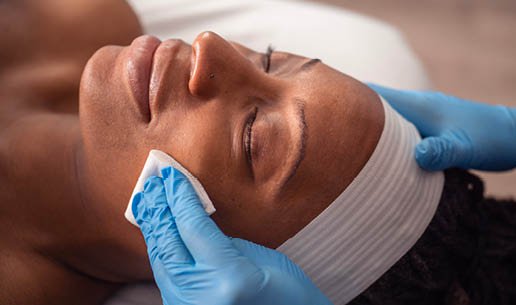 Close-up of esthetician's hands as she performs Brightening Chemical Peel service. 