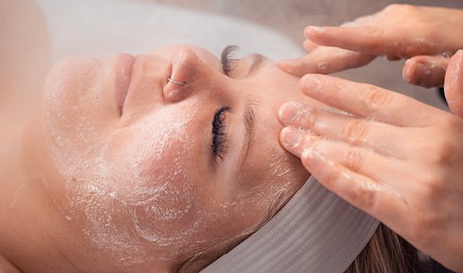 Woman receiving clarifying acne facial at Massage Envy franchised location. 