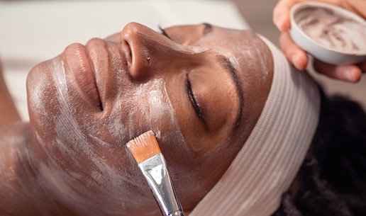 Woman receiving brightening facial at Massage Envy franchised location. 
