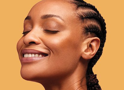 Close-up of woman's face in front of a yellow background. 