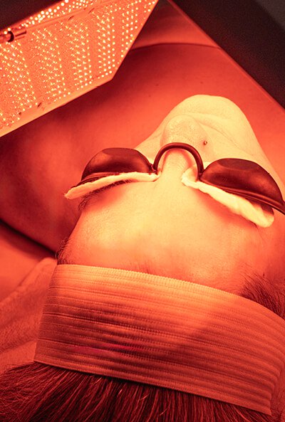 Close-up of a woman's face during a Tone-Balancing Nourishing Light Treatment. 