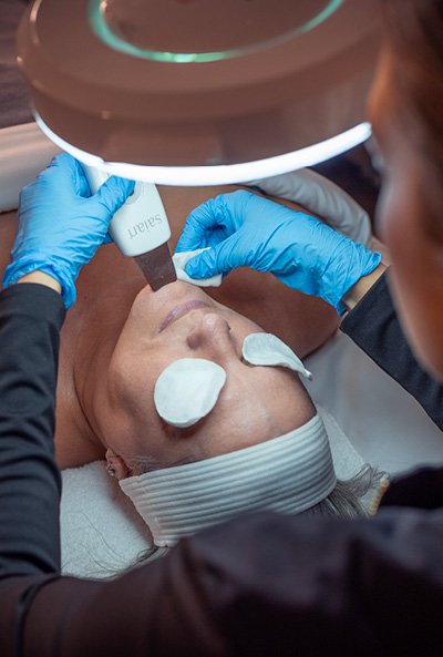 Close-up of esthetician providing a tone-balancing facial. 