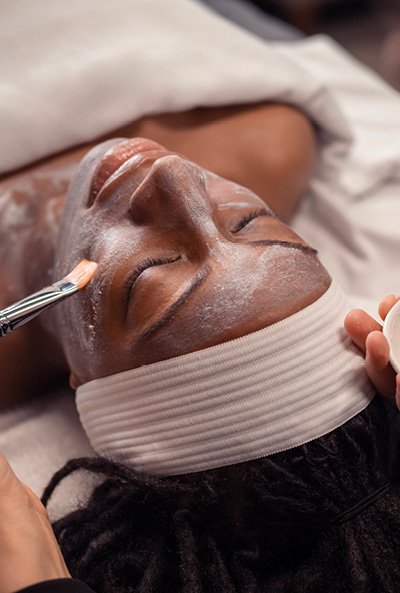 Close-up of woman with her eyes closed as she relaxes during a brightening facial. 