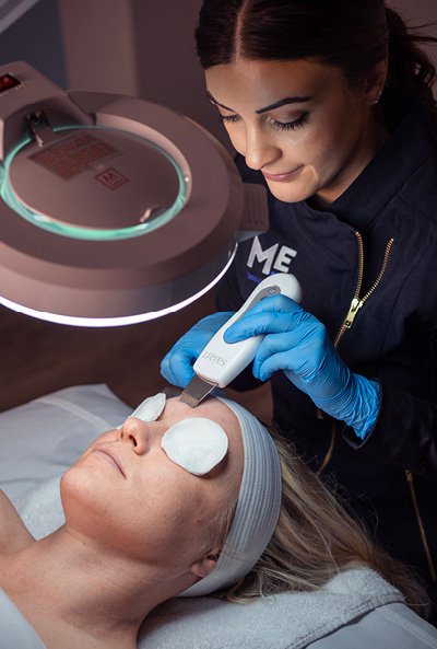 Close-up of esthetician giving a woman a calming facial service. 