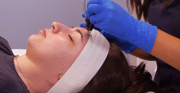 Woman receiving microderm infusion service at Massage Envy clinic. 