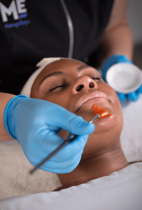 Woman relaxing as Massage Envy esthetician provides her a facial. 