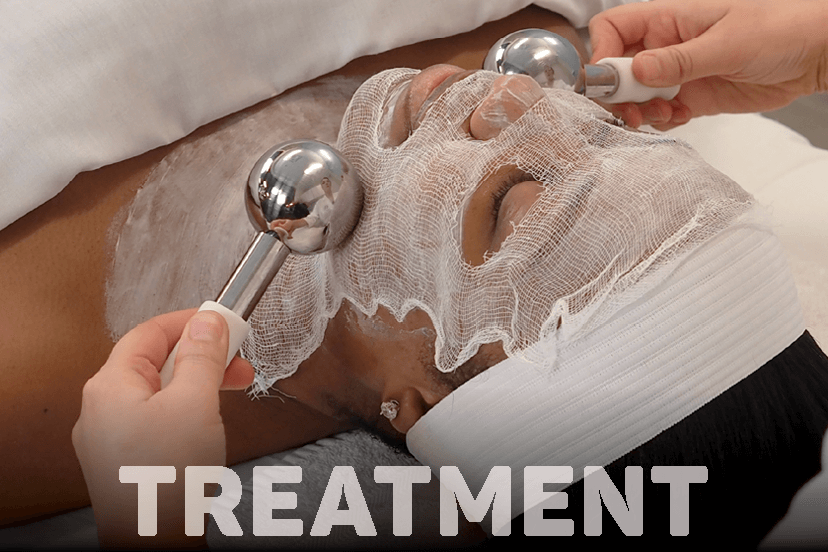 Woman receiving facial massage with cooling globes during nourishing light treatment session.