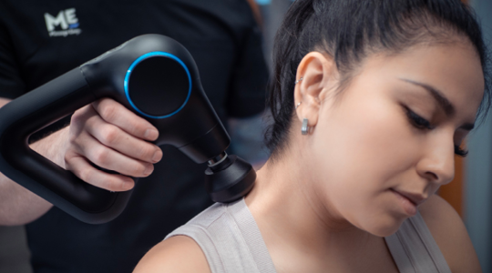 Woman receiving rapid tension relief therapy along her back shoulder.