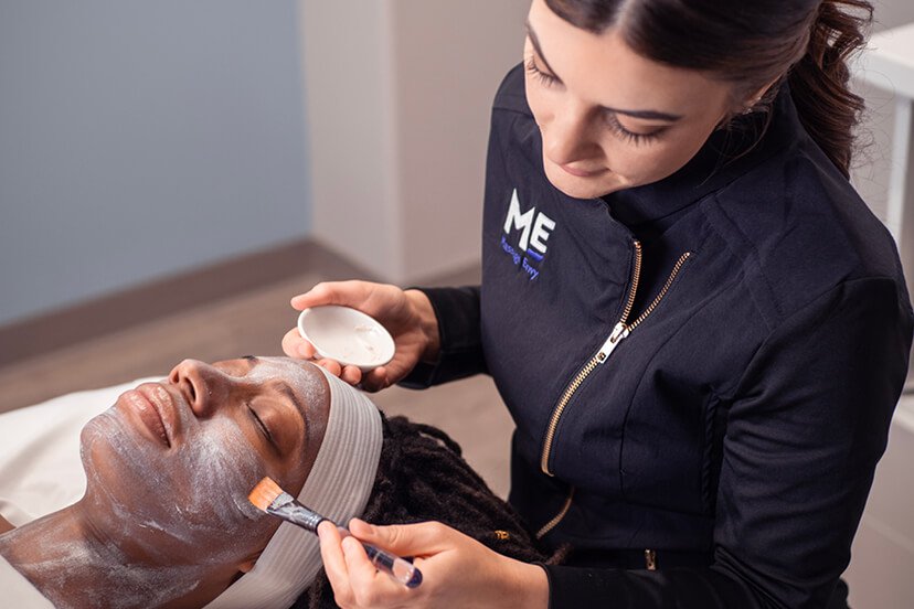 Close-up of esthetician providing facial service to customer. 