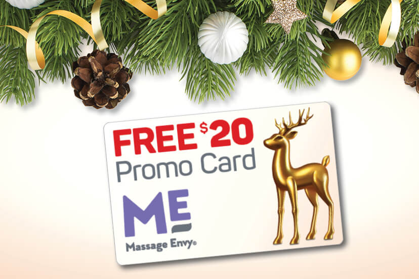 Free $20 promo card. Close-up of Massage Envy promo card with holiday decorations positioned above. 