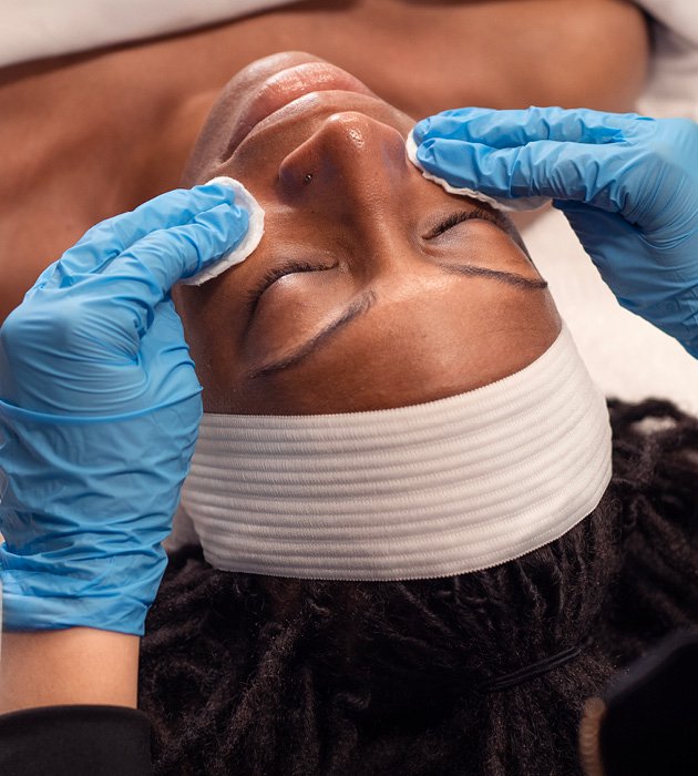 Woman resting with eyes closed during facial service.