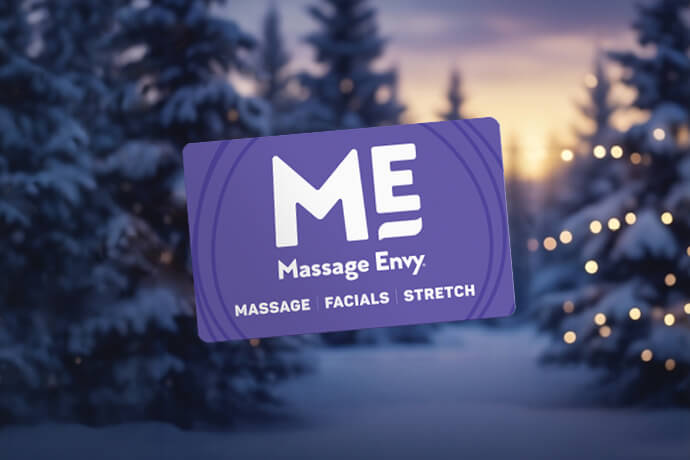 Massage Envy gift card in front of holiday-themed background. 