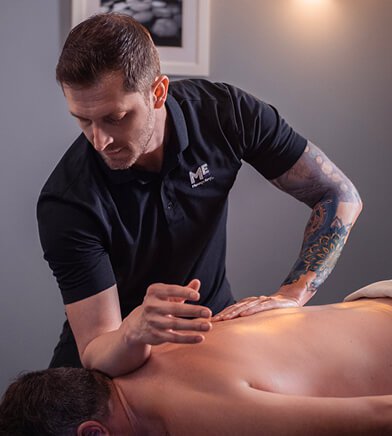 Close-up of massage therapist massaging client on massage table. 