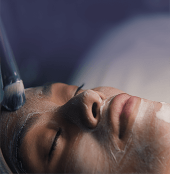 Woman with eyes closed relaxing during her facial session.
